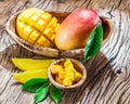 Mango fruit and mango cubes on the wood. Royalty Free Stock Photo