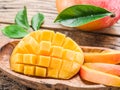 Mango fruit and mango cubes on the wood. Royalty Free Stock Photo