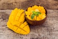 Mango fruit and mango cubes on the wooden table Royalty Free Stock Photo