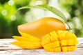 Mango fruits and slice cut with leaf on wood table