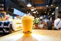 Mango fruity frappe, smoothies and shakes in plastic take away cup on the wooden table in beverage shop Royalty Free Stock Photo