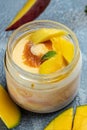Mango ice cream sorbet with mint leaves and fresh mango served in a glass jar. italian dessert gelato