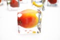 Mango in ice cube isolated on white with depth of field effects. Ice cubes with fresh berries. Berries fruits frozen in Royalty Free Stock Photo