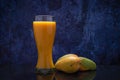 Mango juice glass and group of mangoes on black table Royalty Free Stock Photo