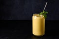 Mango lassi in glass with tube on dark background Royalty Free Stock Photo