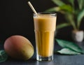 Mango lassi, a healthy smoothie with mango and yogurt, on a dark background.