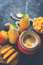 Mango Lassi or smoothie in big glass or small bottles with curd, cut fruit pieces and blender. Royalty Free Stock Photo