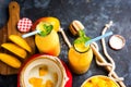 Mango Lassi or smoothie in big glass or small bottles with curd, cut fruit pieces and blender. Royalty Free Stock Photo