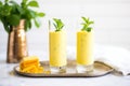 mango lassi in tall glasses with mint garnish