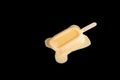 Mango or orange flavor popsicle in a melting process on black Royalty Free Stock Photo
