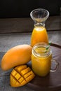 Mango and orange juice and slice of mango on wooden table. Royalty Free Stock Photo