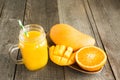 Mango and orange juice and slice of orange on wooden table. Fresh healthy tropical drink. Close up. Royalty Free Stock Photo