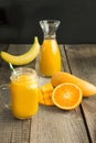 Mango and orange juice and slice of orange on wooden table. Royalty Free Stock Photo