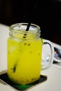 Mango Passionfruit with ice in a tall glass with straw