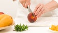 Woman cutting peach. Close up view, white background Royalty Free Stock Photo