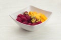 Mango pieces and raspberries with passion fruit in a white bowl Royalty Free Stock Photo