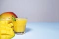 Mango Shake on Blue Background. Healthy Drinking Vitamin Smoothie. Fresh Tropical Mango Fruit Juice. Space for Text, Copyspace.
