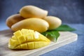 Mango slice with Fresh ripe mango and green leaves on a wooden in black  background. Tropical fruits. Selective focus. Free space Royalty Free Stock Photo