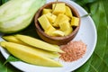 Mango slice on white plate and green leaves from tree tropical summer fruit concept - Ripe mango and green mangoes for snack Royalty Free Stock Photo