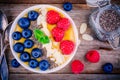 Mango smoothie bowl with raspberries, blueberries, chia seeds and almonds Royalty Free Stock Photo