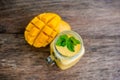 Mango smoothie in a glass Mason jar and mango on the old wooden background. Mango shake.