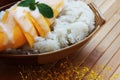 Mango sticky rice is put in a wooden container placed on a brown Royalty Free Stock Photo