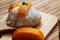 Mango sticky rice is put in a wooden container placed on a brown Royalty Free Stock Photo