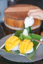 Mango sticky rice. Thai`s popular dessert of mango sticky rice with hand pouring down the coconut milk