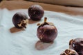 Mangosteen on light tablecloth, Fresh ripe fruits and showing the thick purple skin. is known as
