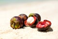 Mangosteen on a sand, beach background, closeup