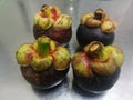 Mangosteen a topical fruit with juicy white segments of flesh inside a thick reddish-brown rind