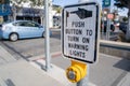 Manhattan Beach, California - Sign instructs pedestrians to push button to turn on the warning lights for cars, to