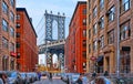 Manhattan Bridge and brick wall old buildings and architectures with people on the street in Brooklyn in DUMBO district, Manhatta