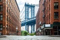 Manhattan Bridge between Manhattan and Brooklyn over East River seen from a narrow alley enclosed by two brick buildings on a Royalty Free Stock Photo