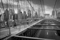 People crossing Manhattan Bridge in black and white.