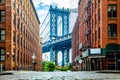 Manhattan Bridge between Manhattan and Brooklyn over East River seen from a narrow alley enclosed by two brick buildings on a Royalty Free Stock Photo