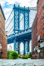 Manhattan Bridge between Manhattan and Brooklyn over East River seen from a narrow alley enclosed by two brick buildings on a Royalty Free Stock Photo