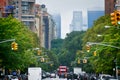 Manhattan buildings skyline from 5th ave. Harlem in a foggy day, through the trees and traffic lights. NYC, USA Royalty Free Stock Photo