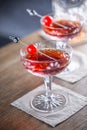 Manhattan classic cocktail as a short drink aperitif with whisky, vermouth, angostura aromatic bitter and cherry garnish Royalty Free Stock Photo