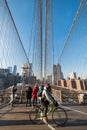 A cyclist passing the Brooklyn Bridge bike path, with a group of tourists walking behind Royalty Free Stock Photo