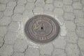 manhole cover on concrete sidewalk, neighborhood near the equator line in a park near Quito