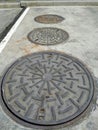 Manhole cover of drain water way near building and street in Thailand