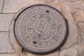 A manhole cover with Chinese characters on a cobbled street, Kumbum, Xining, China Royalty Free Stock Photo