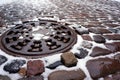 Manhole cover and old traditional stone pavement in winter Royalty Free Stock Photo