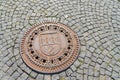 Manhole cover in Prague cobbled road.