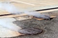 Manhole Cover with Steam Escaping Royalty Free Stock Photo