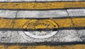 Manhole cover on yellow and white pedestrian crossing. Royalty Free Stock Photo