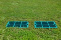 Manhole drainage grates on the lawn with green grass septic tank cover. Royalty Free Stock Photo