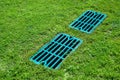 Manhole drainage grates on the lawn with green grass septic tank cover. Royalty Free Stock Photo