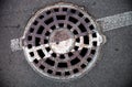 Manhole with metal cover in asphalt with white road marking line Royalty Free Stock Photo